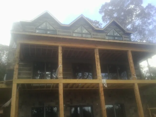 Dormers and porch framing on a large log home under construction — Roof Coating work by our crew in American Fork