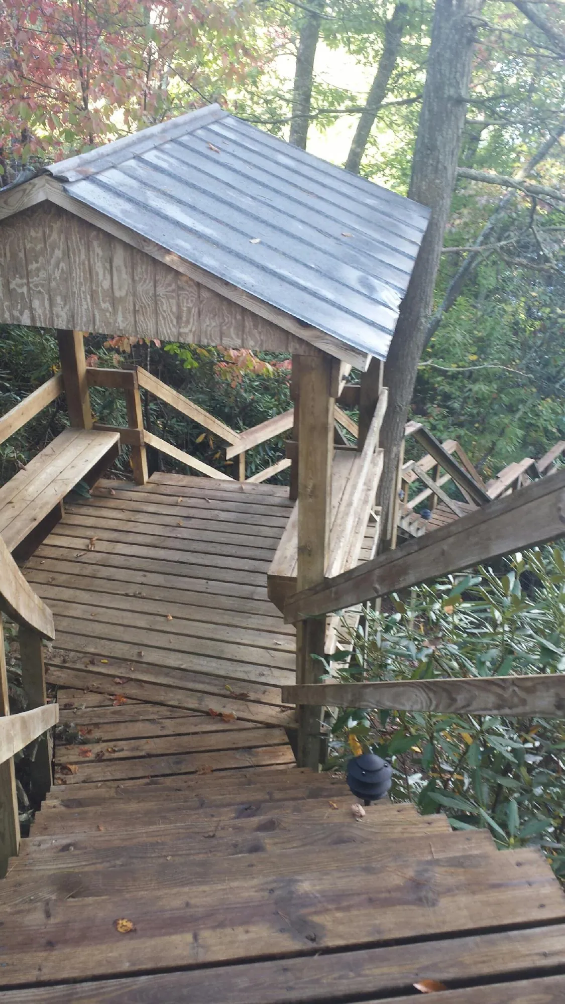 Metal roofed shelter over wooden steps on a wooded walkway — Skylight Repair & Installation work by our crew in American Fork